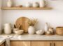 Bright Scandinavian minimal kitchen with light oak cabinets, white walls, neutral ceramic decor, and calm Nordic styling.